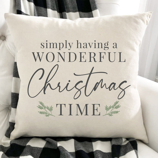 Simply Having a Wonderful Christmas Time Pillow Cover on a cozy couch with plaid throw.