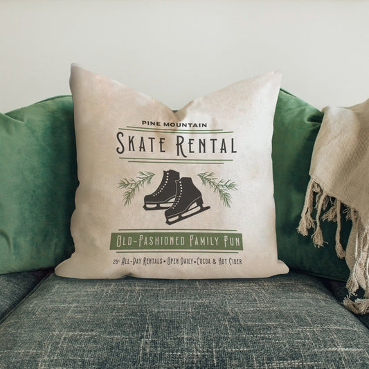 Skate Rental Pillow Cover featuring vintage ice skates design on a cozy couch with green cushions.