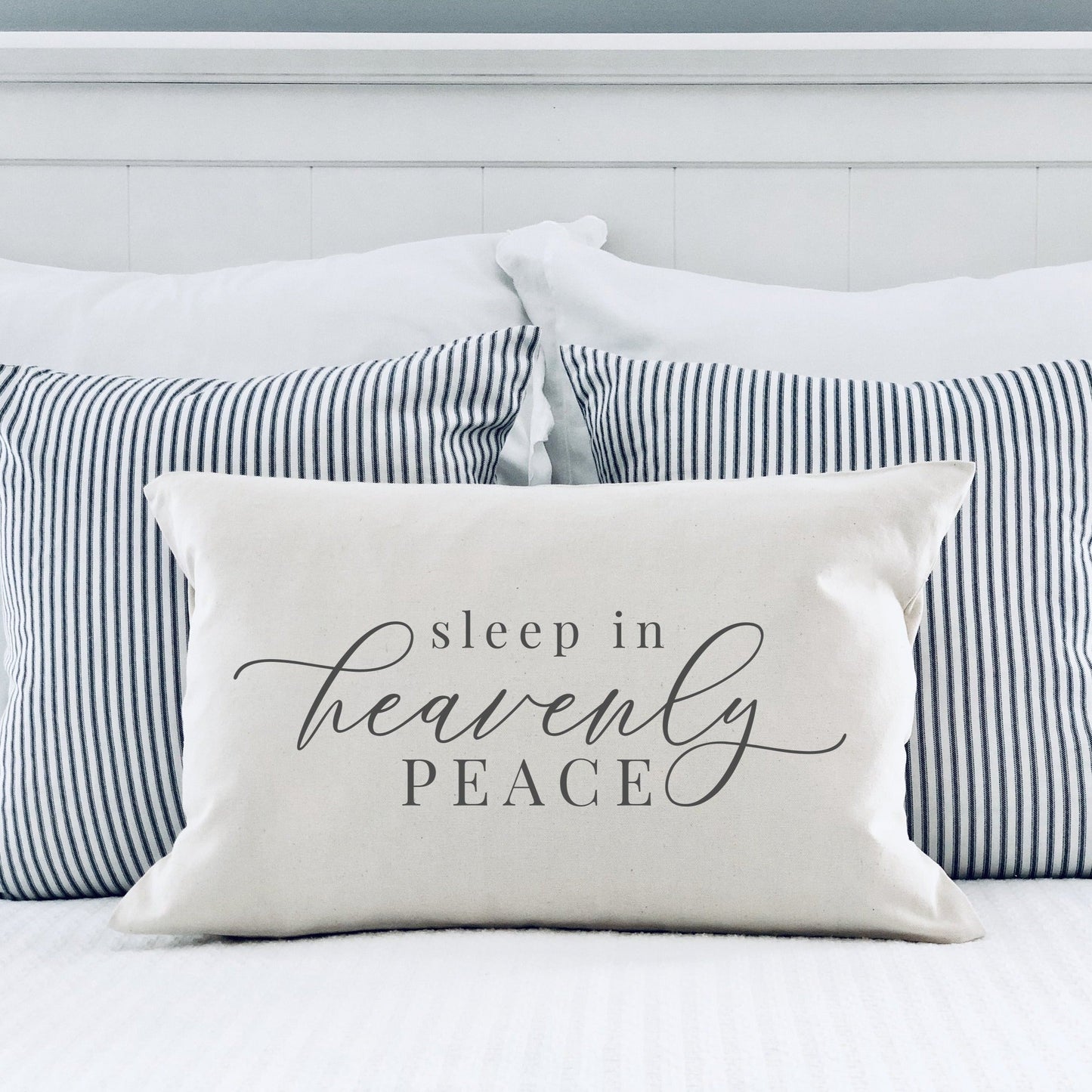 Sleep in Heavenly Peace Pillow Cover 12x20 inch displayed on a bed with striped pillows, creating a cozy holiday atmosphere.