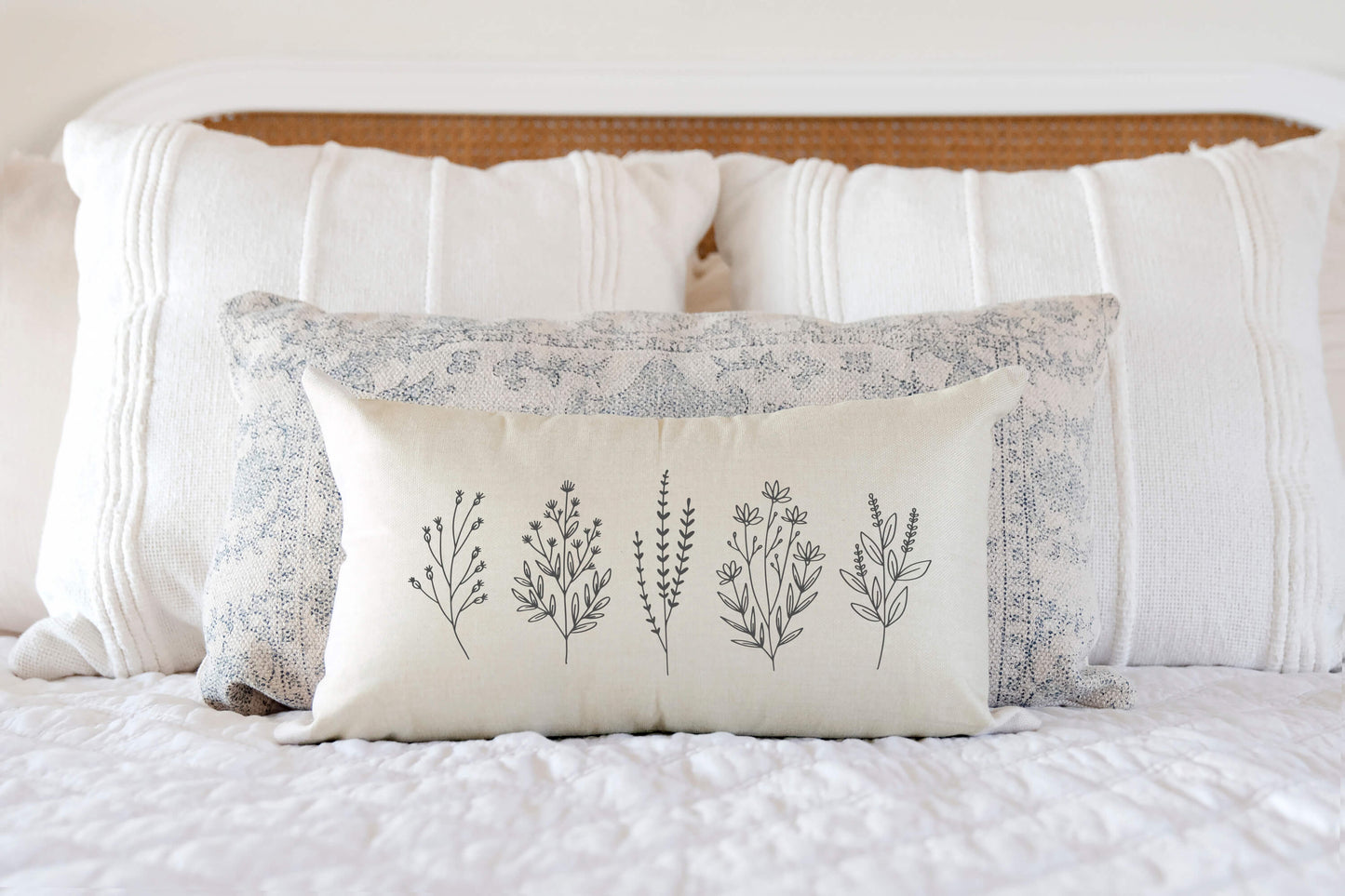 Floral Sprigs Spring Pillow Cover 12x20 inch displayed on a bed with decorative pillows.