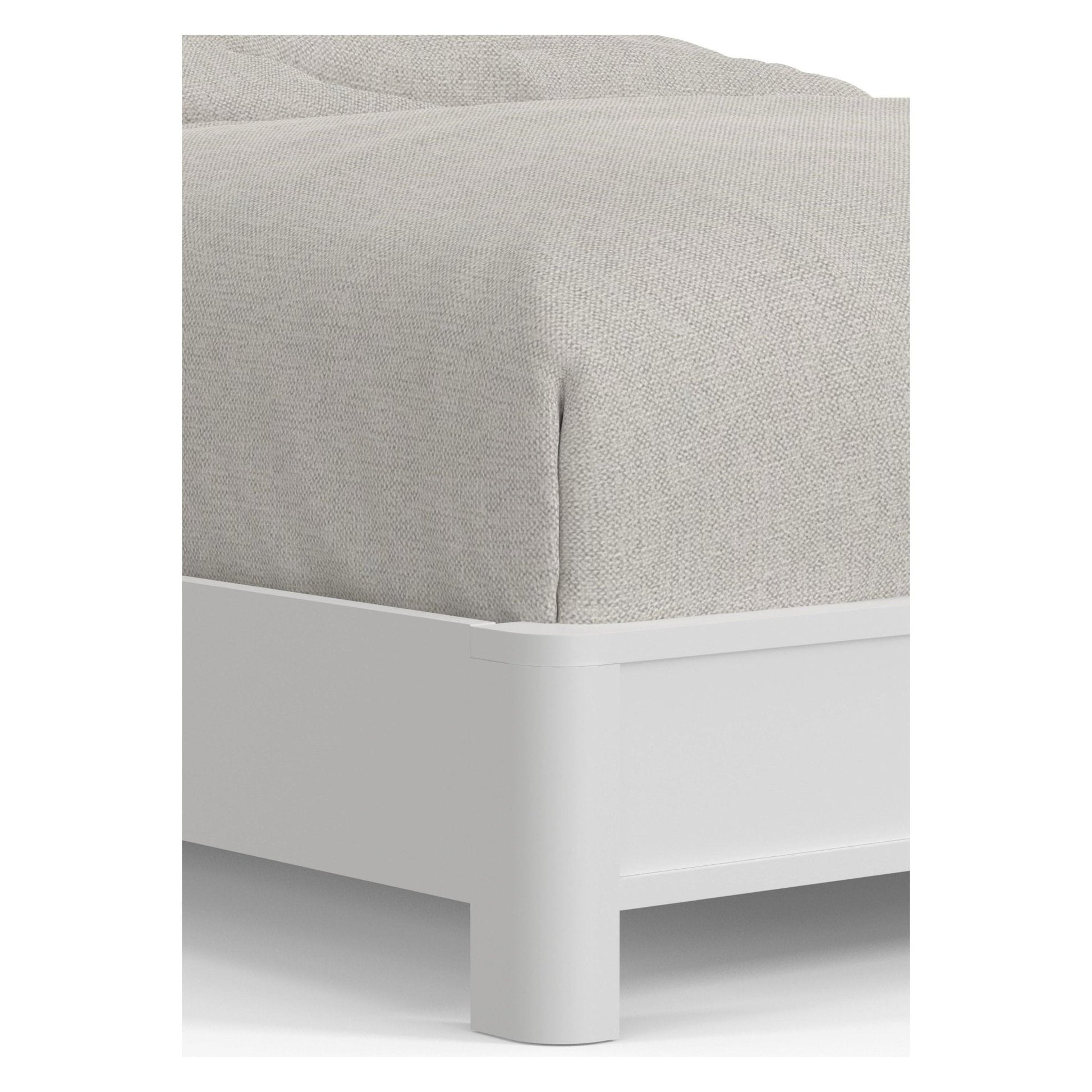 Detail view of the Stapleton Panel Bed showcasing its durable white frame and soft, light gray upholstery.