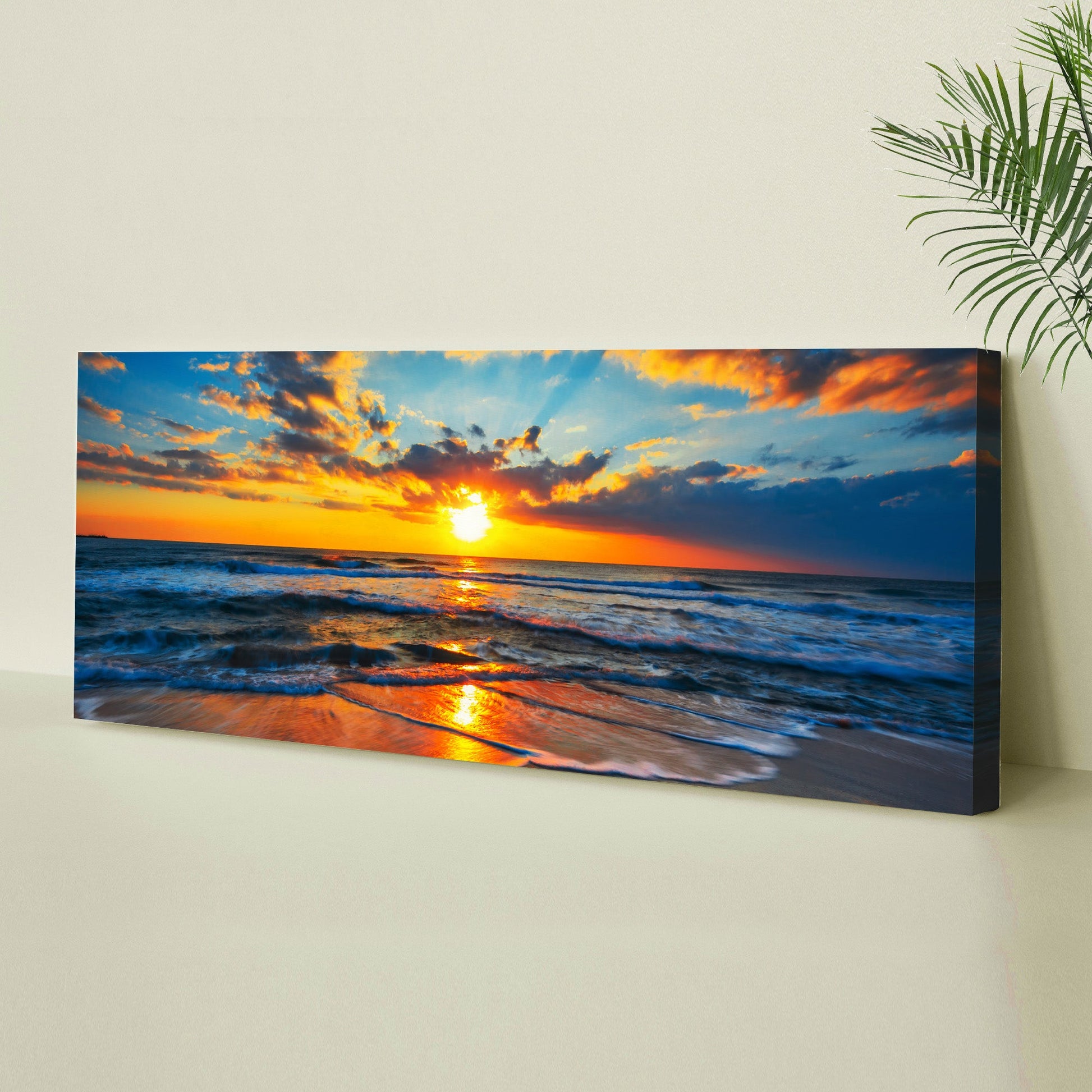 Canvas print of a sunset over the ocean on a wall.