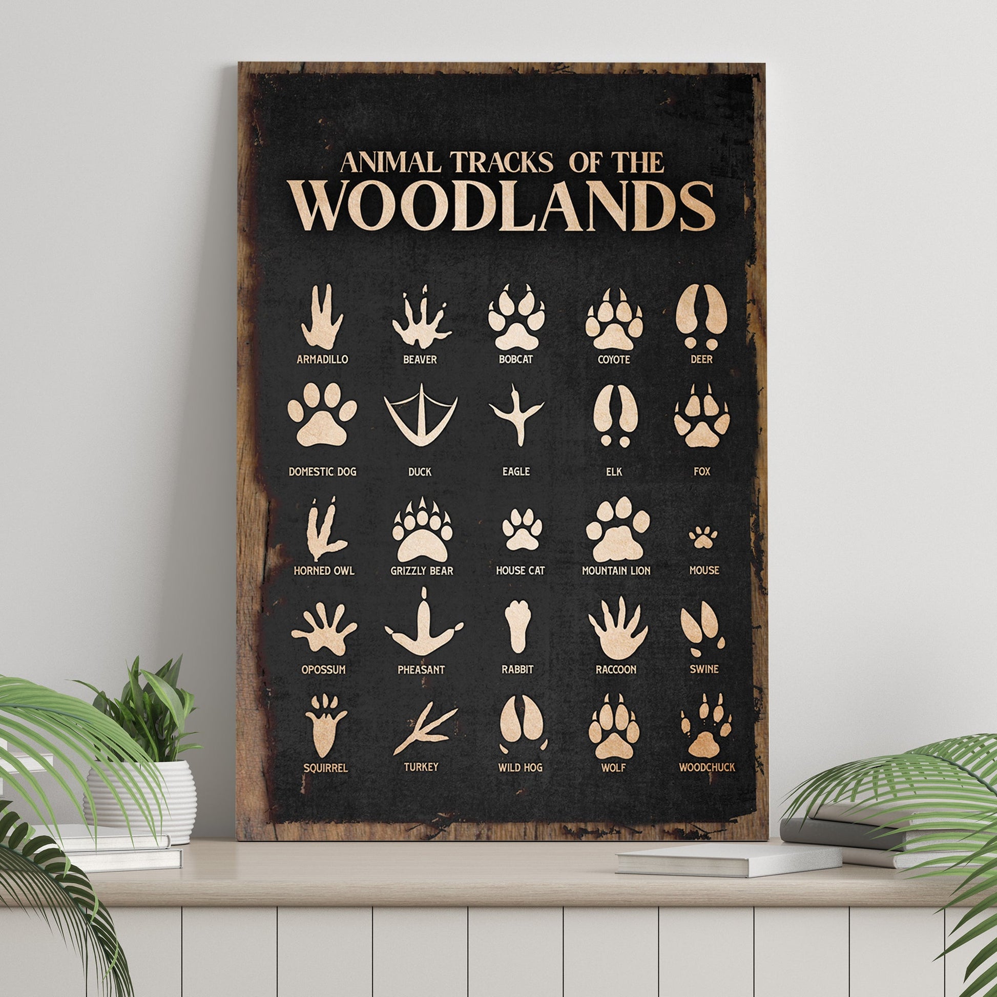 Print titled 'Animal Tracks of the Woodlands' with various animal tracks on a wooden frame.