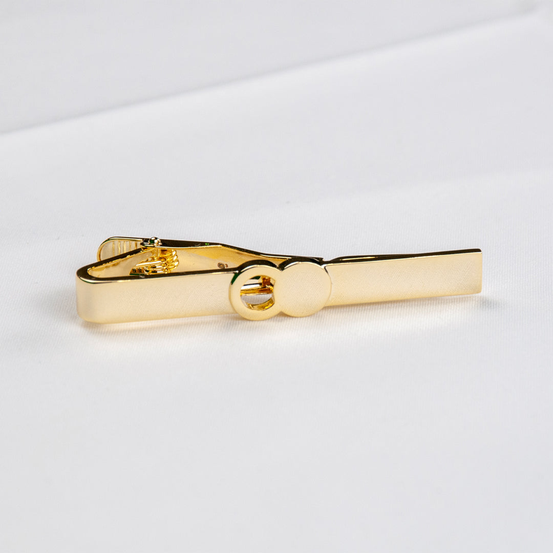 The Empty Tomb Tie Clip in sleek brass design, showcasing its stylish finish on a white background.