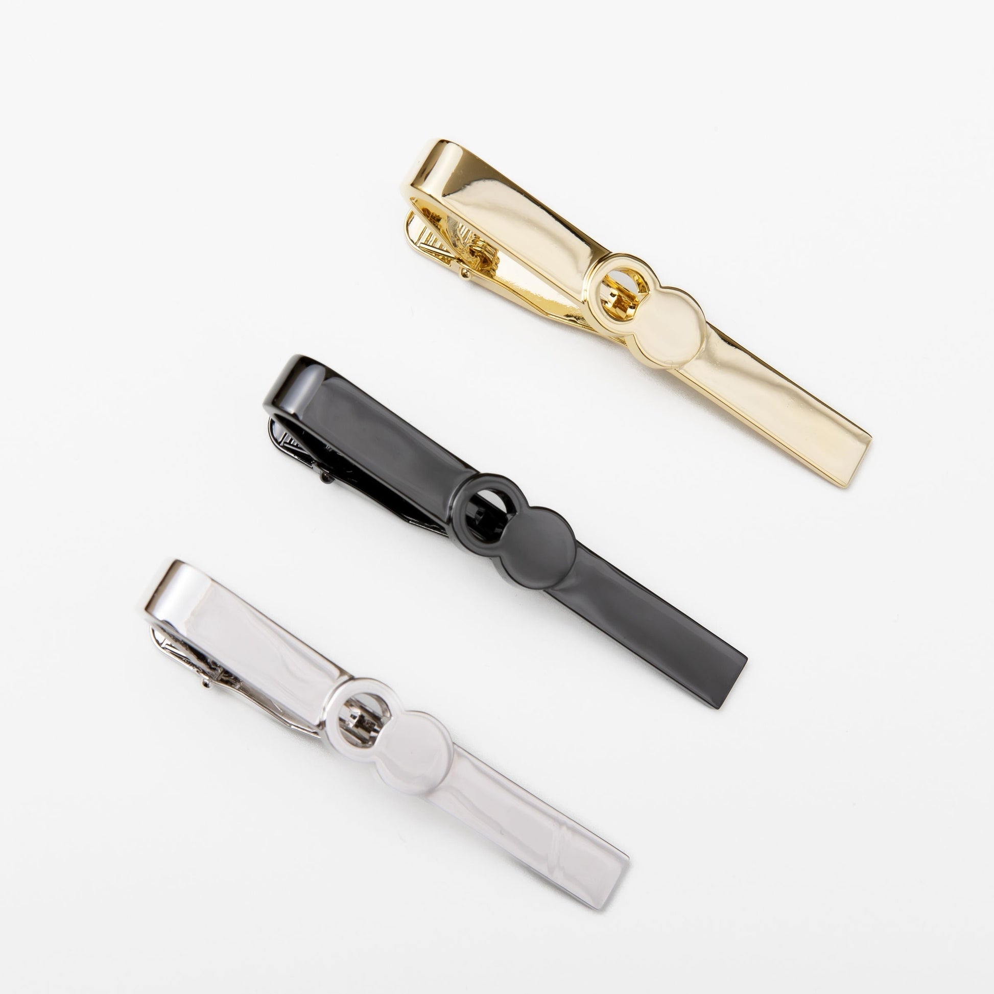 The Empty Tomb Tie Clip collection featuring gold, black, and silver tie clips on a white background.