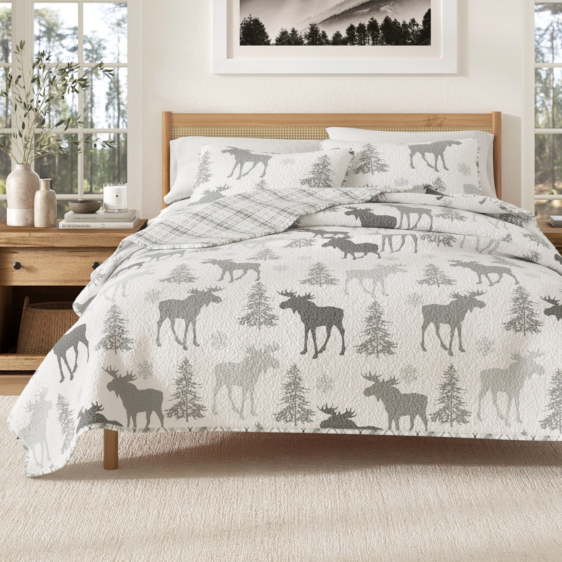 Bed with moose and tree patterned comforter in a bedroom setting