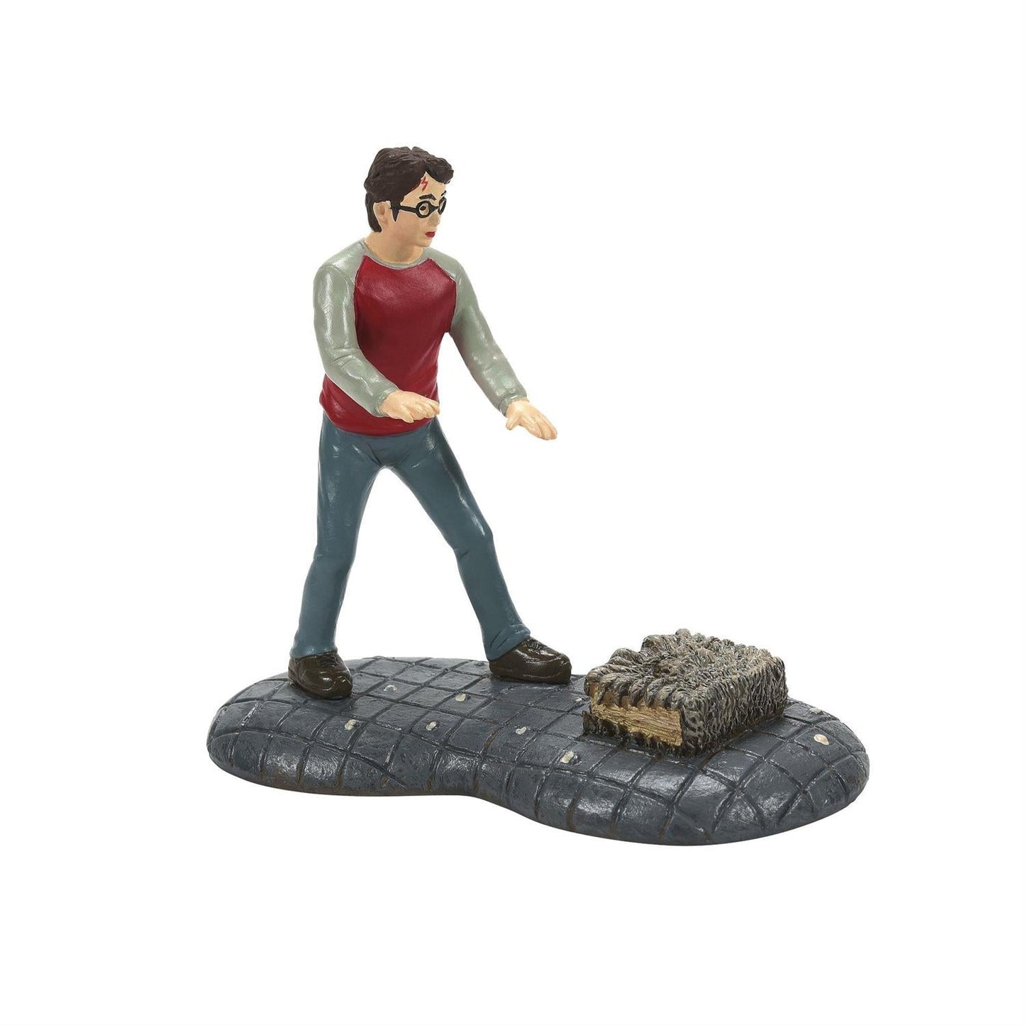 Harry Potter And His Monster Book figurine of Harry Potter standing near the Monster Book of Monsters.