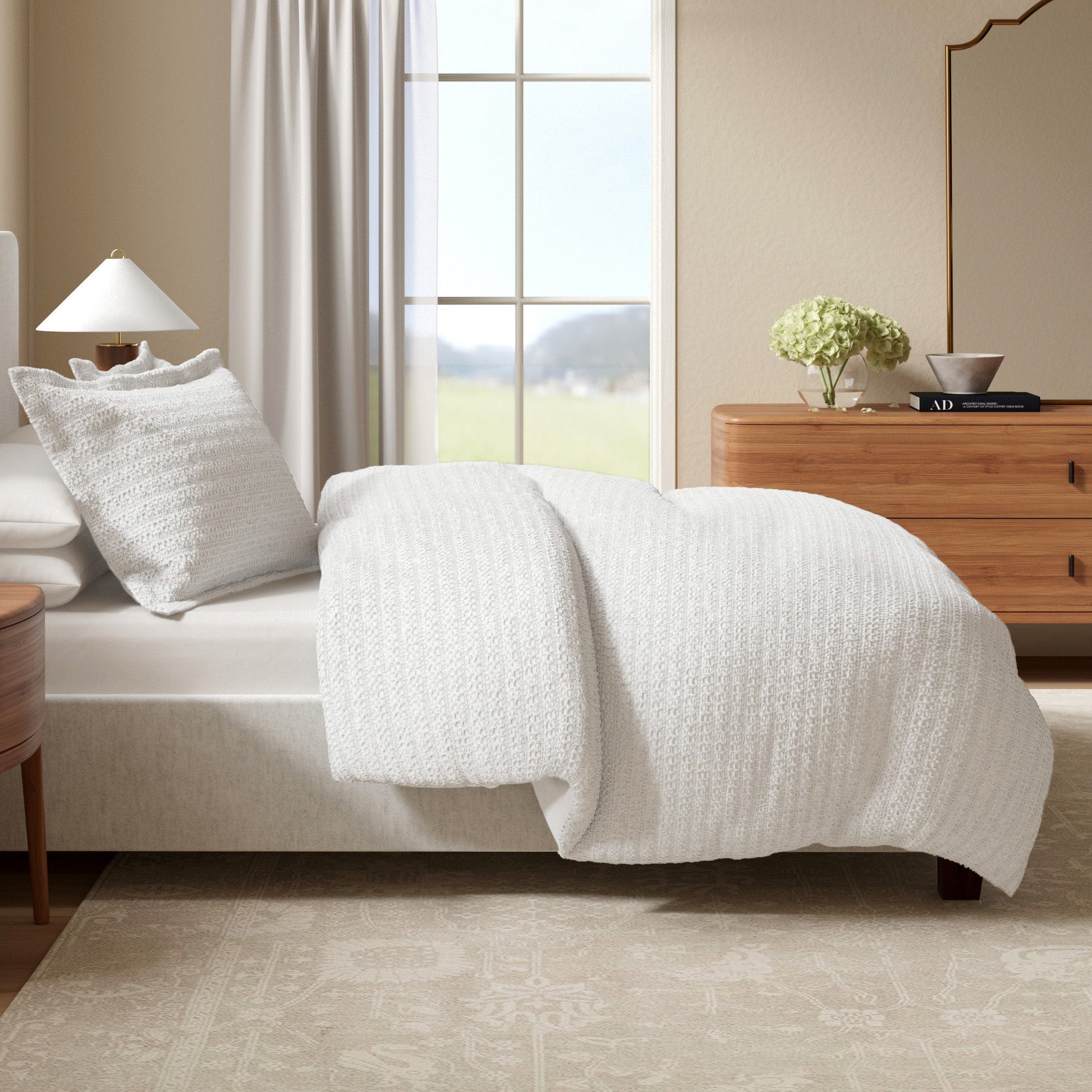 Neatly made bed with white bedding in a bedroom setting.