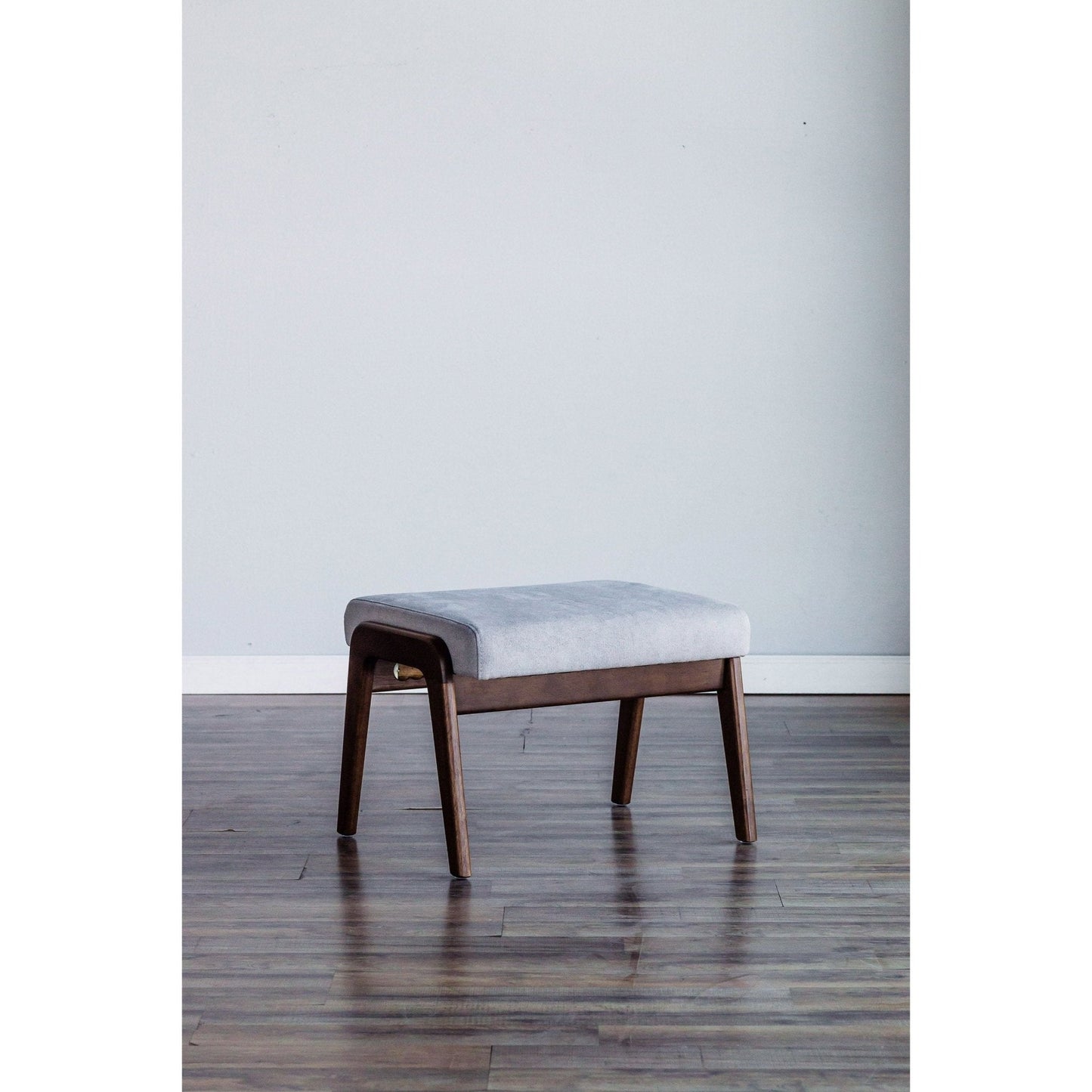 Zephyr Slate Footrest with light gray upholstery and medium brown solid wood frame in modern room setting.